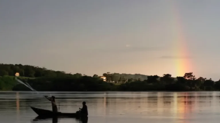 Barca navegando por el río Nilo al atardecer, con un arcoíris al fondo, símbolo de reflexión, transición y esperanza