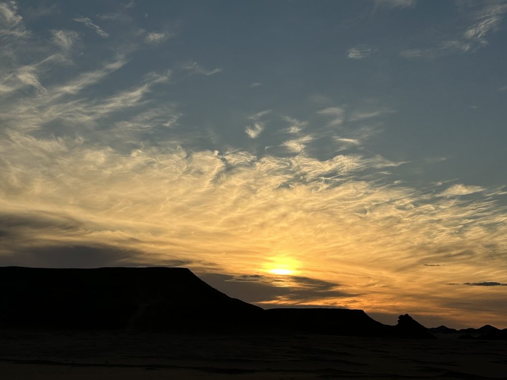 Amanecer en el desierto, con luz suave sobre la arena y el horizonte despejado, símbolo de silencio, tiempo y conciencia.