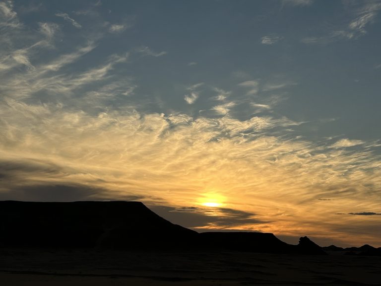 Amanecer en el desierto, con luz suave sobre la arena y el horizonte despejado, símbolo de silencio, tiempo y conciencia.