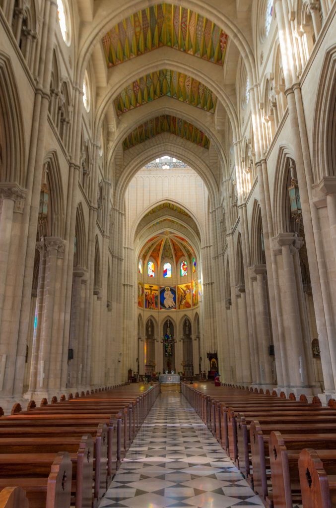 Interior de la Catedral de la Almudena con bancos vacíos en un acto institucional