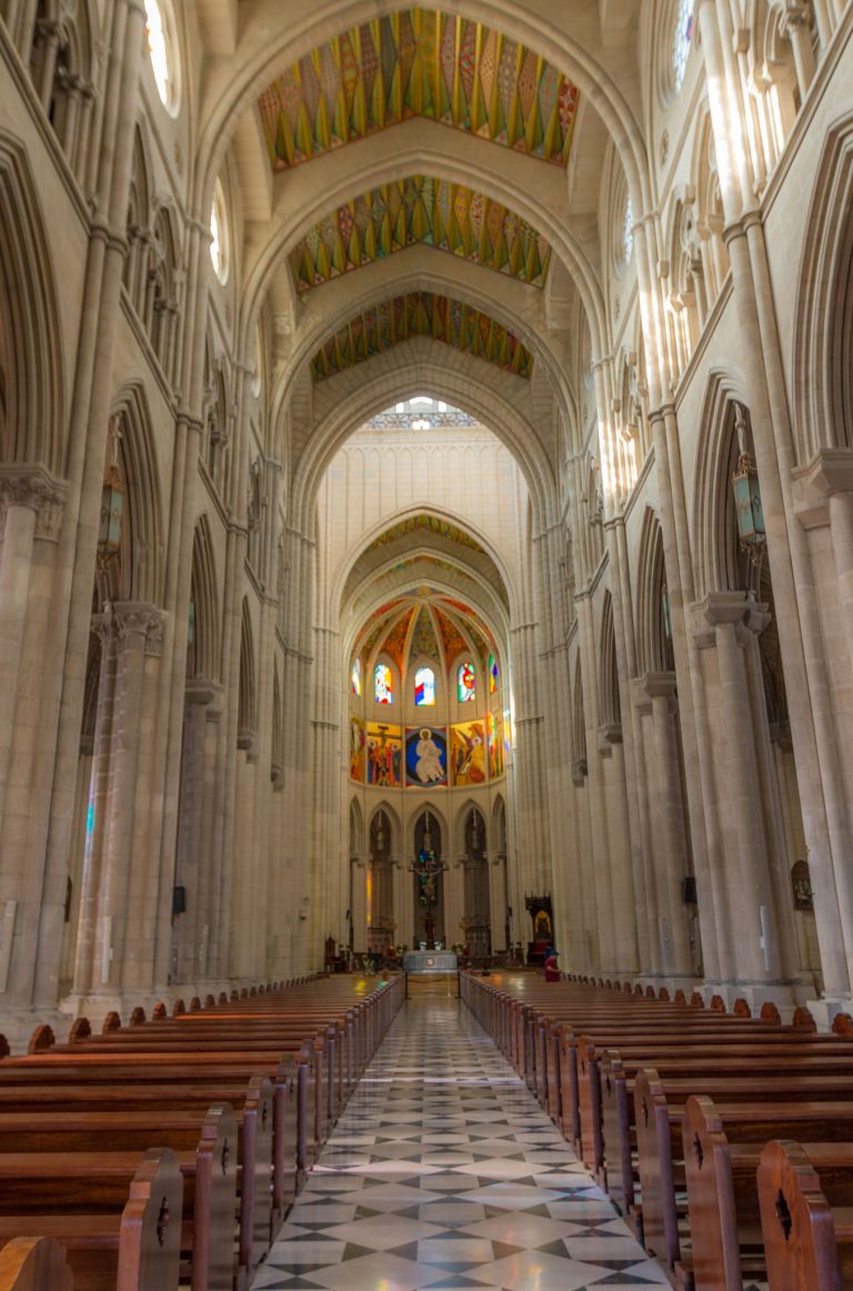 Interior de la Catedral de la Almudena con bancos vacíos en un acto institucional