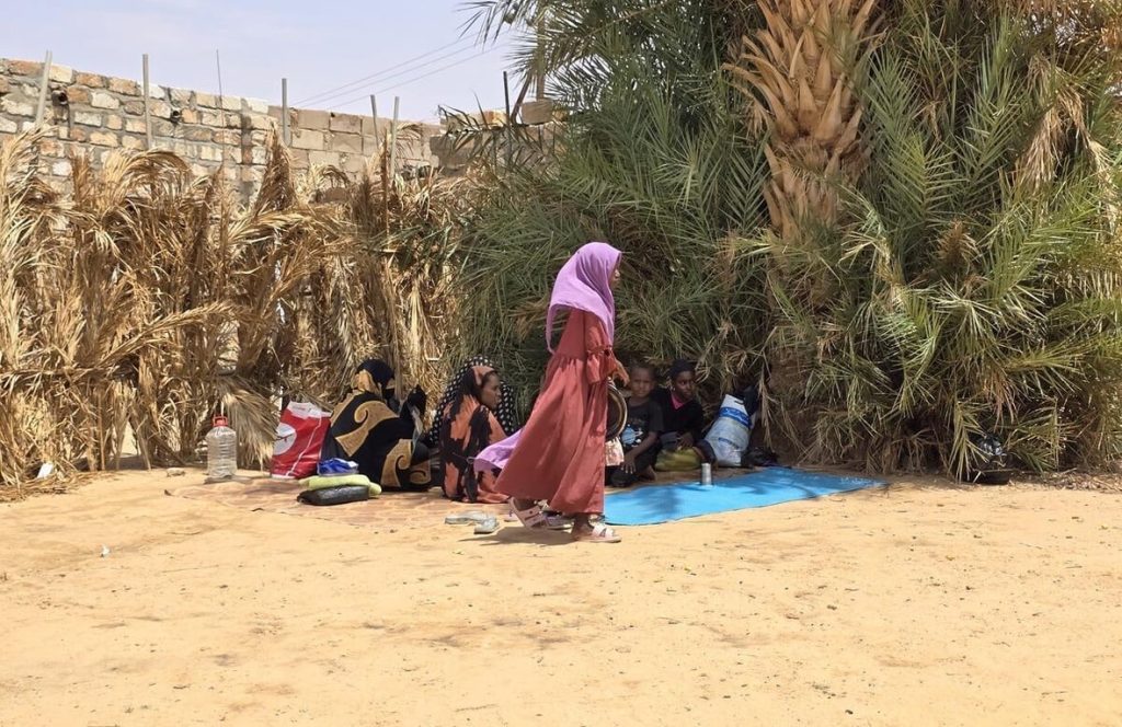 Sudanese refugee woman preparing traditional coffee with spices in an informal market in Kufra, Libya