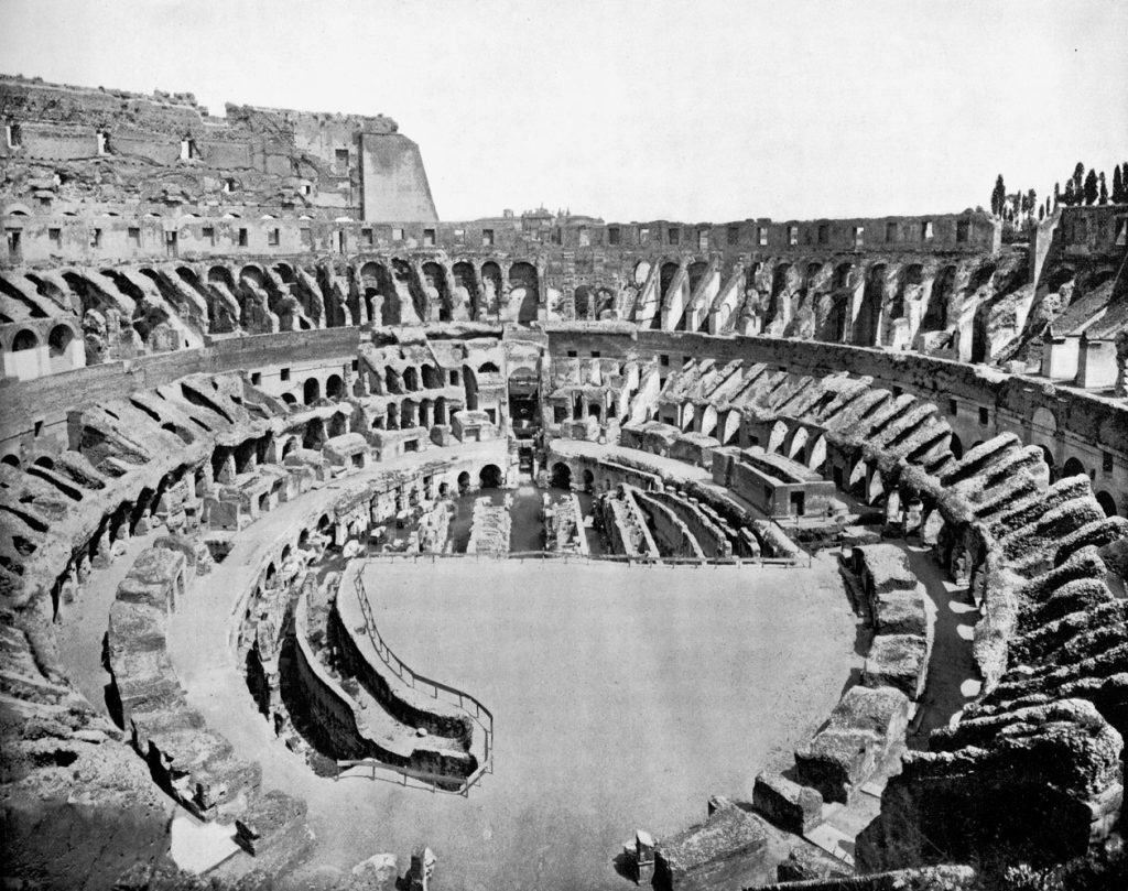 Historic black and white view of the Roman Colosseum, symbol of imperial spectacle, gladiatorial violence and public humiliation as entertainment during the Roman Empire.